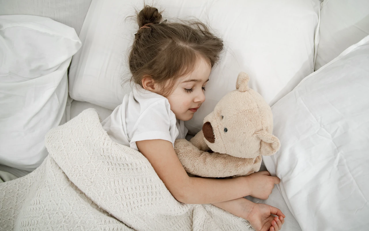 enfant qui dort paisiblement un doudou dans les bras
