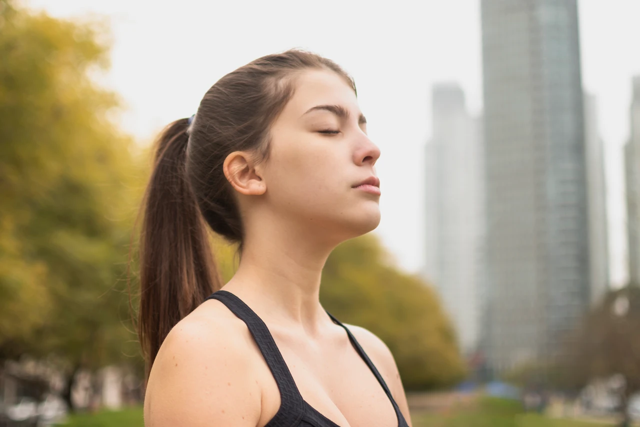 jeune femme prenant une pause bien-être respiration en extérieur
