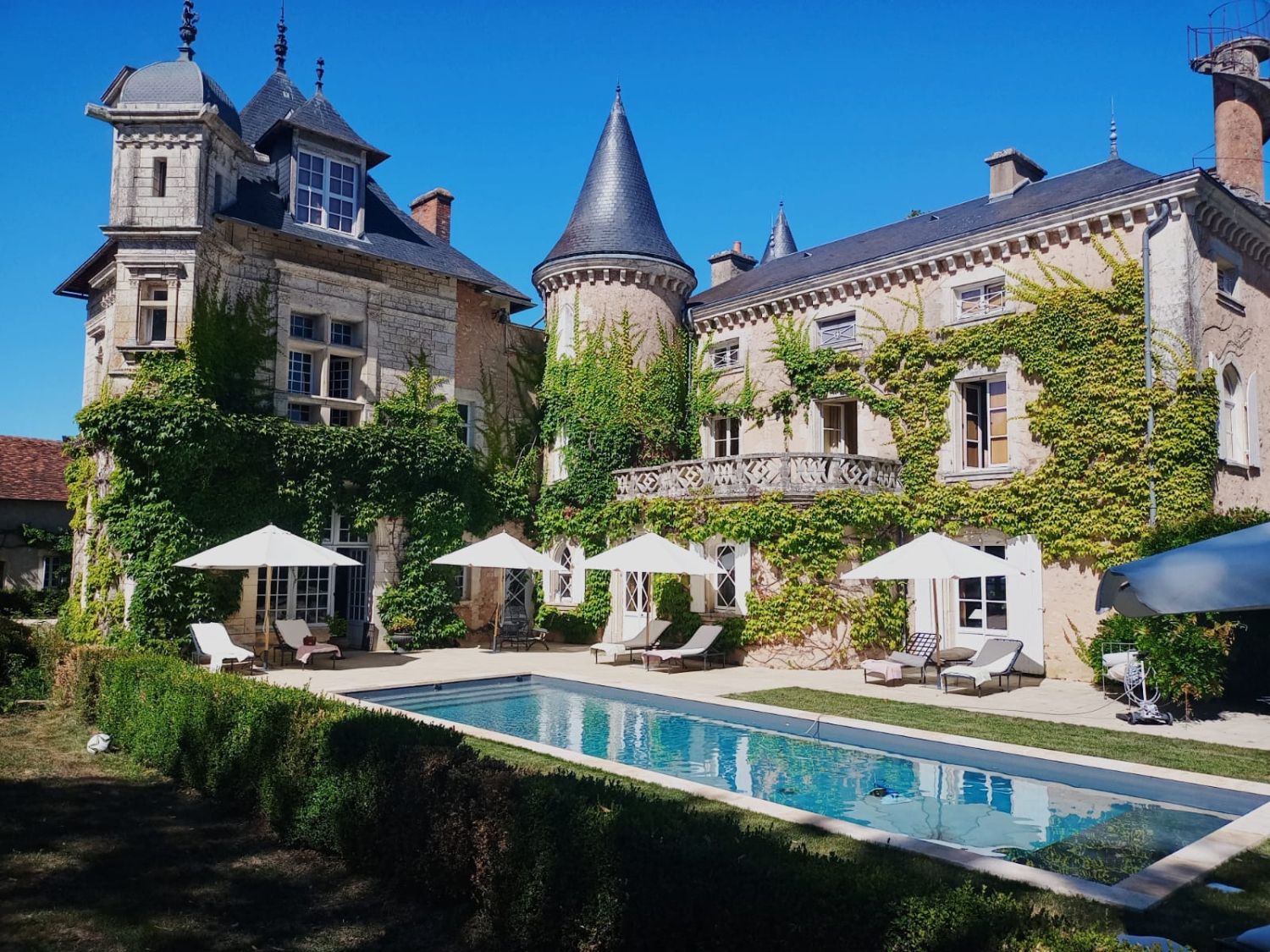 A castle by the water in a green setting 