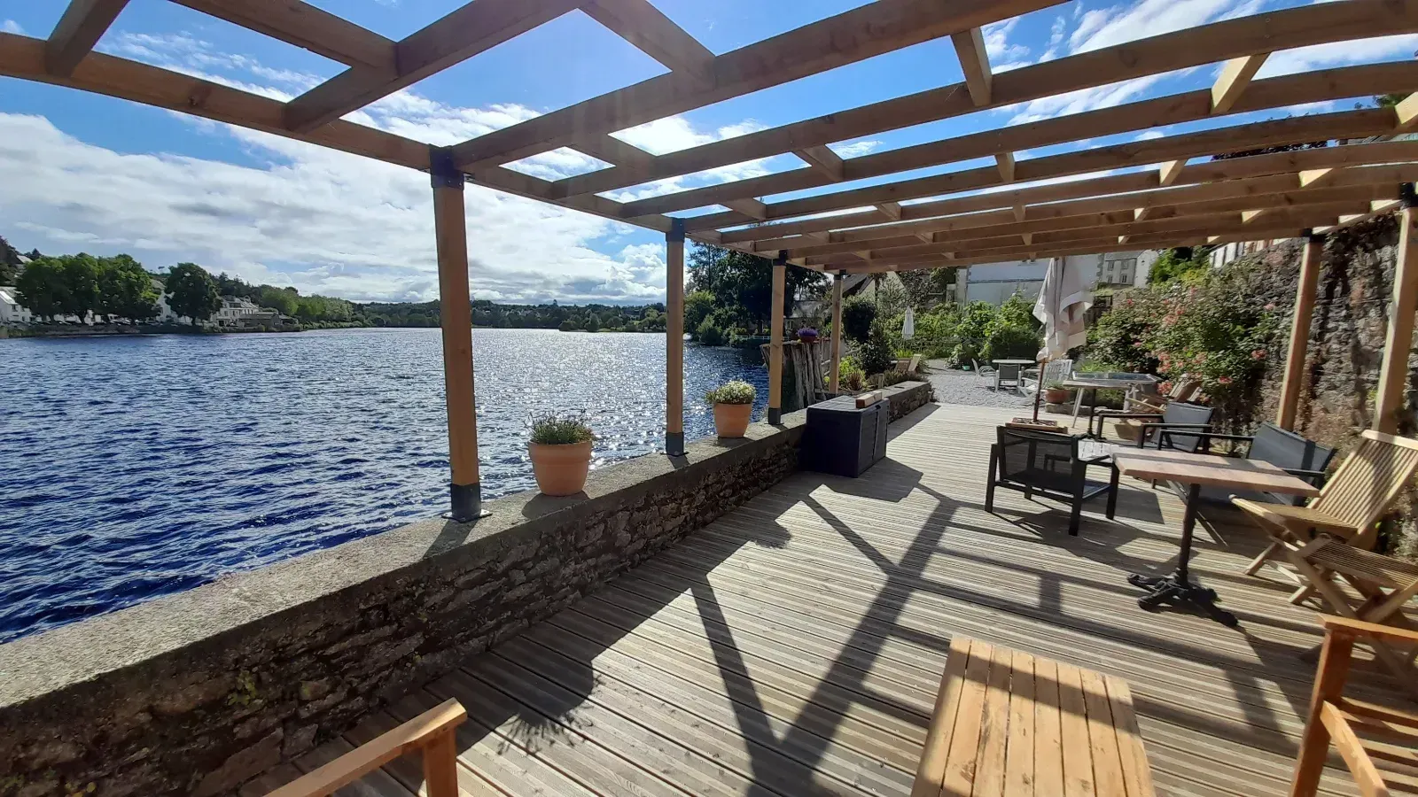 Beautiful lakeside garden with large wooden terrace overlooking the water