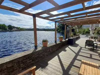 Beautiful lakeside garden with large wooden terrace overlooking the water