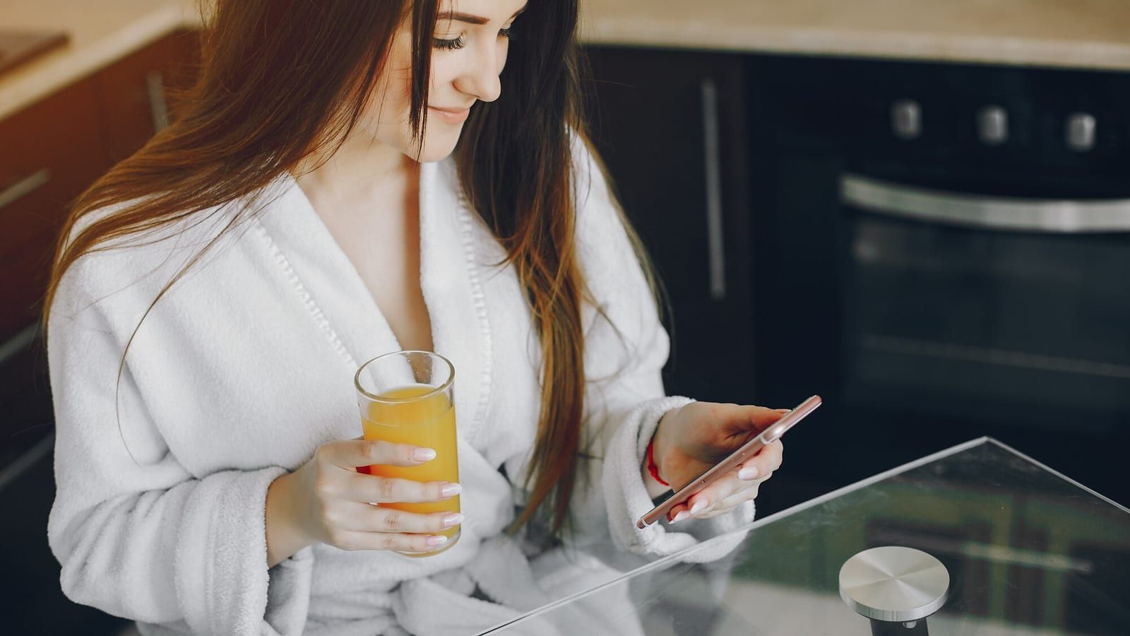 Smartfon z otwartym grafikiem zabiegów SPA leżący na blacie recepcji hotelowej obok białych ręczników
